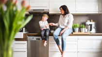 Happy senior woman with a small boy in the kitchen at home, relaxing. Happy senior woman with a small boy in the kitchen at home, relaxing.