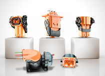 Five orange industrial electrical connectors and plugs displayed on white pedestals and surface in a product showcase. Five orange industrial electrical connectors and plugs displayed on white pedestals and surface in a product showcase.